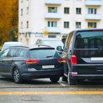 Dvojica áut narazených na parkovisku, znázorňujúca nehody spôsobené nešikovnou jazdou alebo neopatrnosťou.