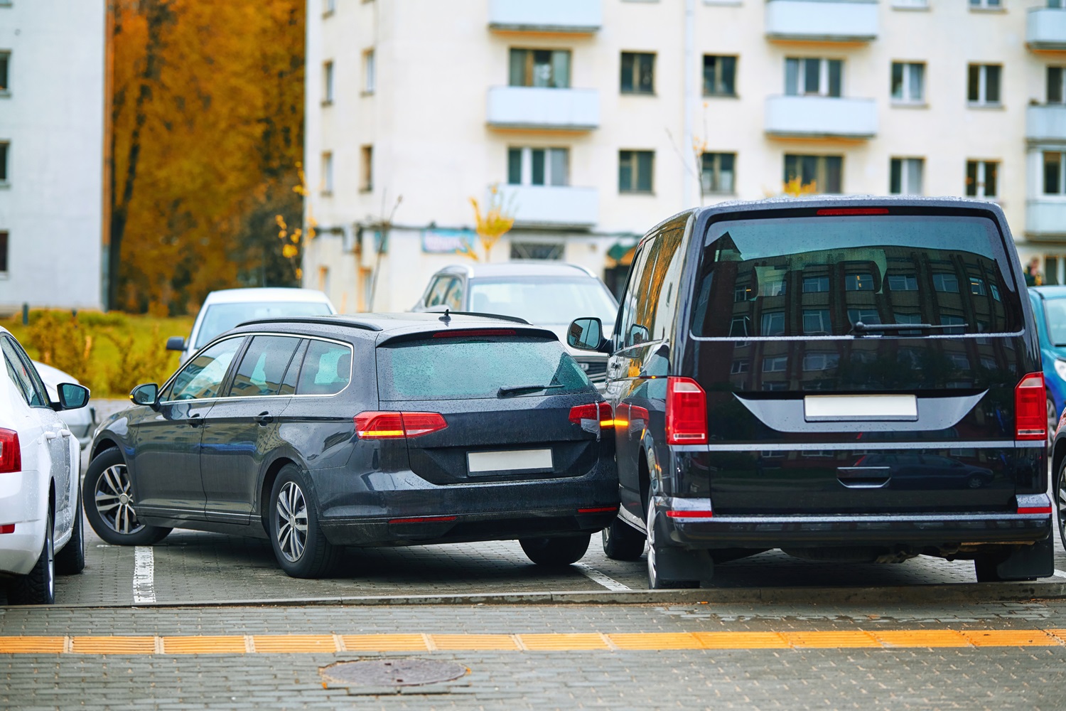 Dvojica áut narazených na parkovisku, znázorňujúca nehody spôsobené nešikovnou jazdou alebo neopatrnosťou.